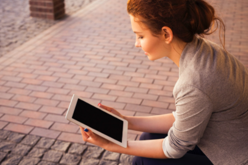 a girl holding an ipad/tablet