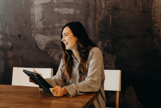 girl holding an ipad/tablet and smiling