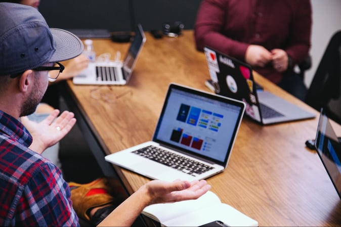 young people sitting together with laptops and networking