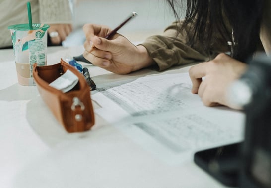 Student taking notes while studying, representing early-career professionals preparing for workplace skills.